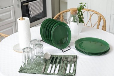 Mutfaktaki yemek masasında temiz tabaklar ve bardaklar.