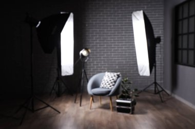 Profesyonel ekipmanı ve koltuğu olan karanlık fotoğraf stüdyosunun içi.