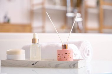 Aroma ayırıcı ve kozmetik ürünler banyodaki masada, yakın plan.