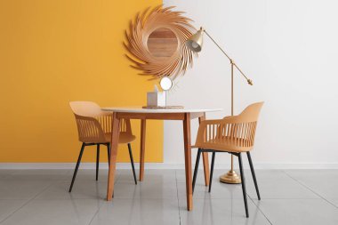 Yemek masası, altın lambası ve aynası olan şık bir oda.