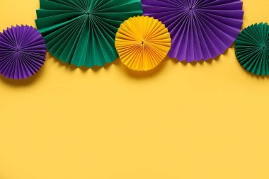 Sarı arka planda renkli kağıt vantilatörler. Mardi Gras Kutlaması