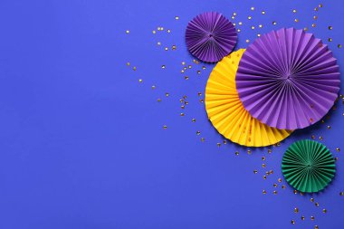 Mavi arka planda konfeti olan renkli kağıt hayranları. Mardi Gras Kutlaması