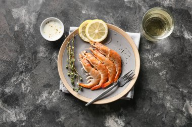 Lezzetli haşlanmış karides ve koyu arkaplanda limon tabağı.