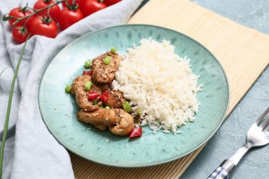 Tatlı ve ekşi tavuk, tabakta pilav, paspas ve çatal turkuaz grunge arka planda, yakın plan.