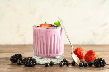 Farklı böğürtlenli taze meyve püresi ve ahşap masada nane şekeri.