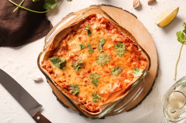 Hafif arka planda lezzetli enchilada, bıçak ve baharatlı fırın yemeği.