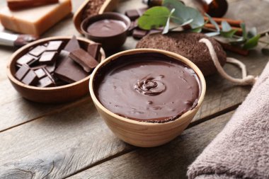 Ahşap arka planda erimiş çikolatalı spa kompozisyonu, yakın plan.