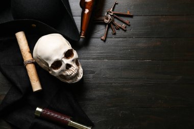 Korsan şapkalı kafatası, hazine haritası, karanlık arka planda dürbün ve şişe.