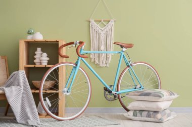 Raflar, yastıklar ve bisiklet yeşil duvarın yanında.