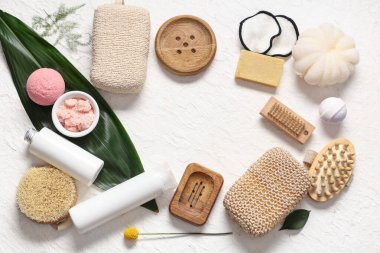 Banyo malzemelerinden yapılmış çerçeve, kozmetik ürünler ve hafif arka planda bitki yaprağı