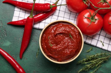 Yeşil arka planda taze biberli ve domatesli kırmızı biber sosu.