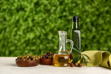 Dekan ve bir şişe taze zeytinyağı açık havada beyaz masada.