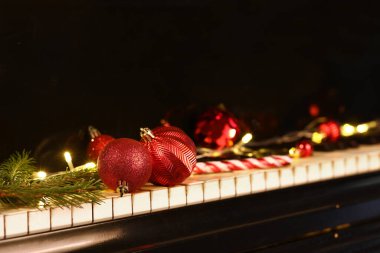 Piyano tuşlarında kırmızı Noel topları