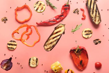 Kırmızı arka planda uçuşan farklı lezzetli ızgara sebzeler.