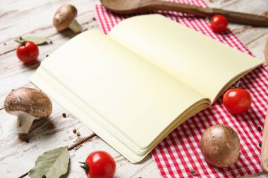 Boş tarif kitabı, sebzeler ve baharatlar açık ahşap masada.