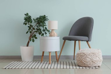 Lambalı sandalye, çiçekli sandalye ve oda turkuaz duvarının yanındaki puf.