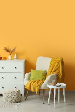 Beyaz koltuklu, kahve masalı ve çekmeceli bir sonbahar salonu.