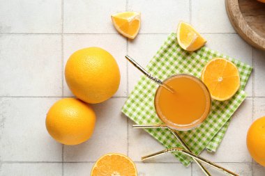 Taze portakallı ve beyaz fayanslı bir bardak lezzetli meyve suyu.