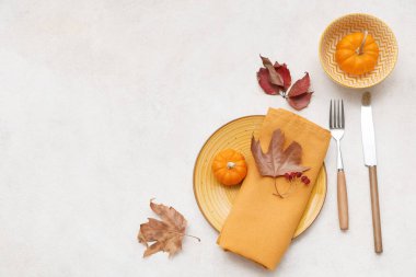 Taze balkabaklarıyla ve beyaz arka planda sonbahar yapraklarıyla güzel bir masa.