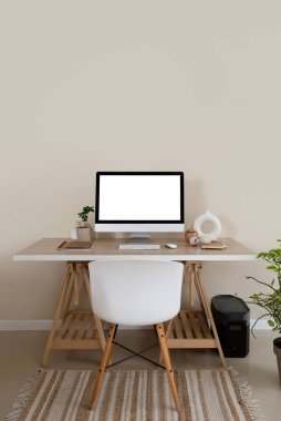 Modern bilgisayar beyaz duvarın yanındaki masada