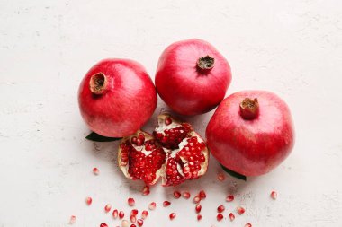 Beyaz zemin üzerinde tohum bulunan taze olgun narlar.