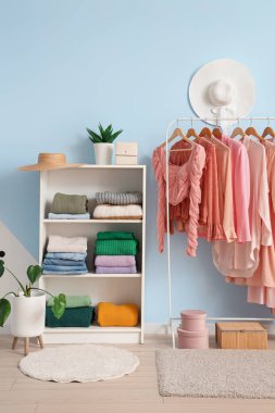 Soyunma odasında elbise ve askılar var.