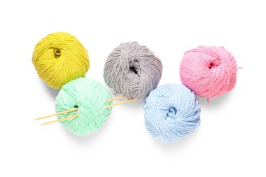 Beyaz arka planda iğneli renkli örgü ipliği