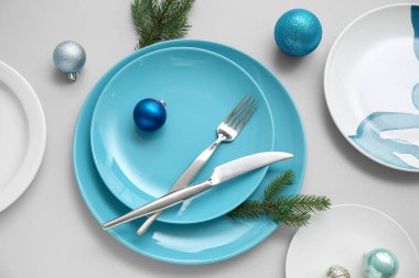 Gri arka planda Noel topları ve köknar dallarıyla güzel bir masa.