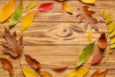 Ahşap arka planda düşen güzel yapraklardan yapılmış çerçeve