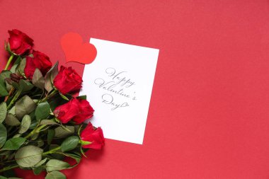 Mesajlı tebrik kartı Mutlu VALENTINE Günü ve kırmızı arkaplanda güzel gül çiçekleri