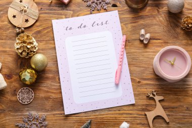 Ahşap zemin üzerinde saat ve Noel dekoru olan boş yapılacaklar listesi