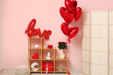 Sevgililer Günü için dekore edilmiş odanın içi raf ünitesi ve balonlarla dolu.