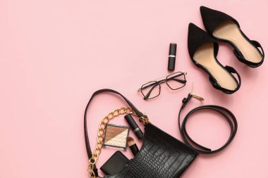 Pembe arka planda şık kadın aksesuarları, ayakkabıları ve kozmetik ürünleri olan kompozisyon