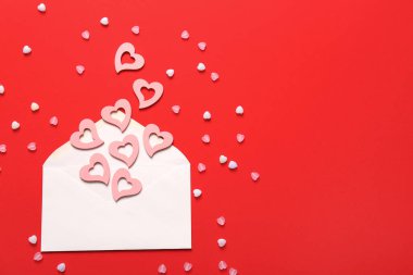 Zarflı kompozisyon ve kırmızı arka planda kalpler. Sevgililer Günü kutlaması