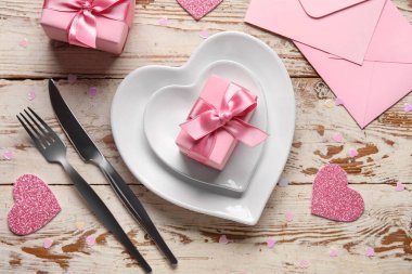 Kalpler, hediye kutuları ve beyaz ahşap arka planda zarflarla dolu güzel bir masa. Sevgililer Günü kutlaması