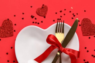 Kalpler ve kırmızı arka planda konfeti olan güzel bir masa. Sevgililer Günü kutlaması