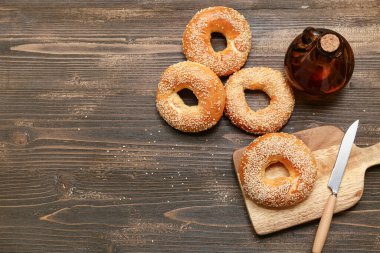 Tahta arka planda susam tohumlu lezzetli simit kesme tahtası