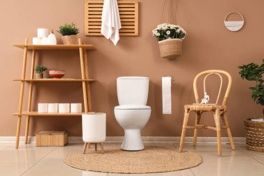 Tuvaletin içinde klozet, raf ünitesi ve sandalye var.