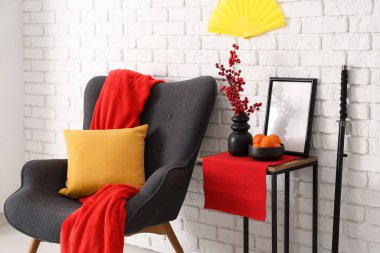 Çin Yeni Yılı için dekore edilmiş oturma odasının içinde koltuk ve masa var.