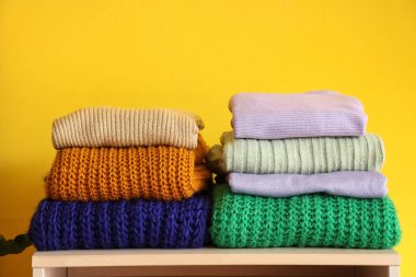 Odadaki raflarda örülmüş şık süveterler.