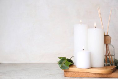 Sazlık yayıcı ve okaliptüs dalı beyaz arkaplanda yanan mumlar