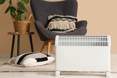 Modern konveksiyon ısıtıcısı ve gri koltuğu olan şık bir oturma odası.