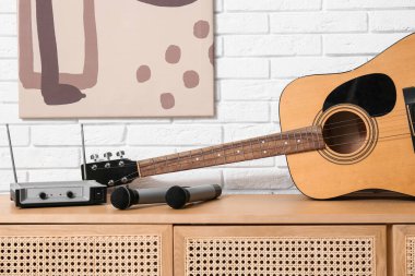 Modern akustik gitar ve mikrofonlar şık oturma odasında, yakın plan.