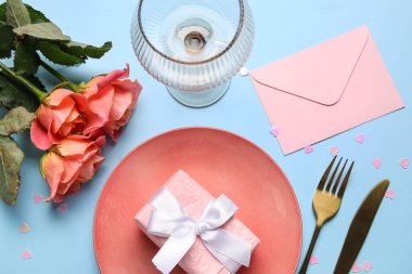 Hediye kutusu, zarf ve mavi arka planda güzel güller olan şık bir masa. Sevgililer Günü kutlaması