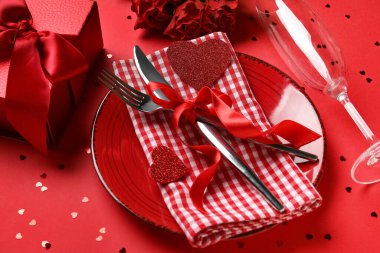 Kırmızı güller, kalpler ve renk arkaplanlı hediye kutusuyla güzel bir masa. Sevgililer Günü kutlaması