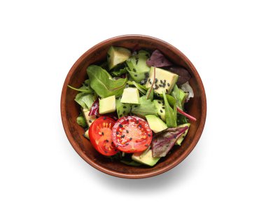 Bir kase lezzetli avokado salatası, vişneli domates ve gri arka planda susam tohumları.