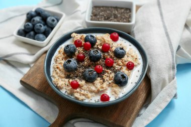 Peçeteli kompozisyon, lezzetli yulaf ezmesi ve mavi arka planda böğürtlen, yakın plan.