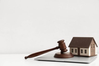 Beyaz arka planda açık arttırma tokmağı ve dizüstü bilgisayarı olan ev modeli