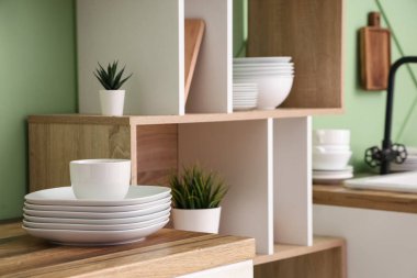 Mutfaktaki ahşap tezgahta temiz tabaklar ve fincanlar, yakın plan.