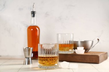 Masanın üzerinde bulanık arka planda bir bardak rom ve buz. Yakın çekim.